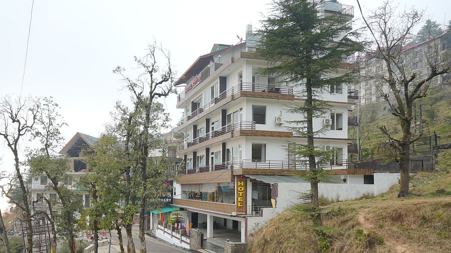 Image of the hotel from a side angle with trees in the background | DLS Hotel Shiva Sanctuary and Spa